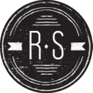 The R. S. Custom Design logo is a faded black circle with white outlines within and a white letter R and a white letter S in the center.